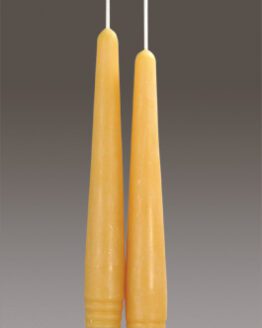 Two 6" Taper - White beeswax candlesticks hanging on a gray background.