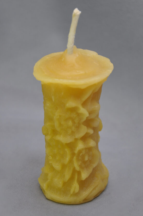 A cropped image of a small gold flower pillar candle
