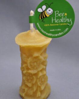 A smaller image of a small gold flower pillar candle with a label