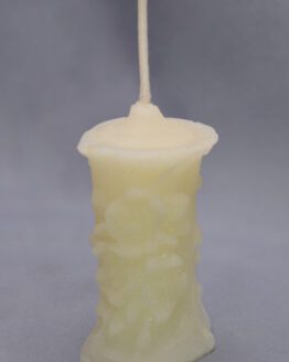 A small white flower pillar candle