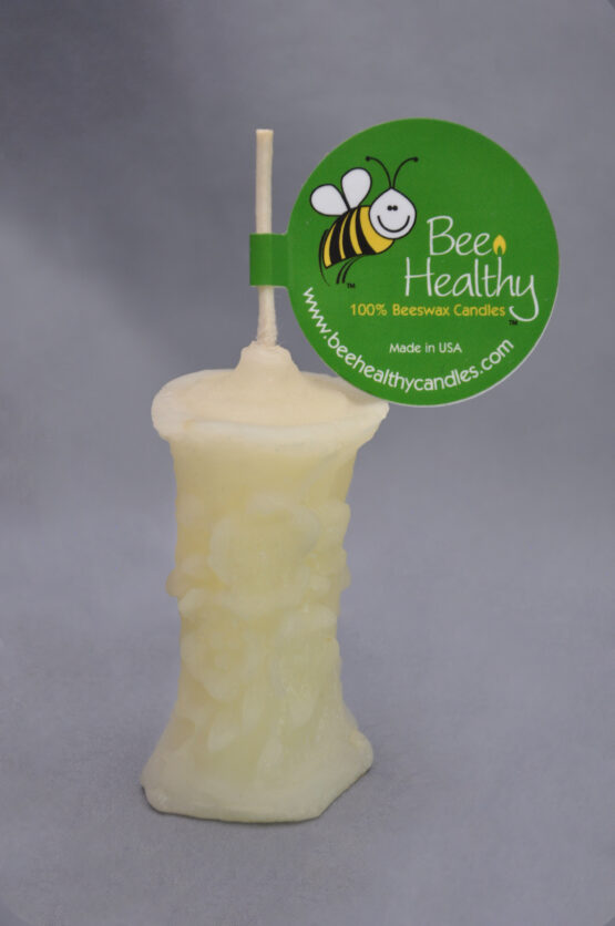 A cropped image of a small white flower pillar candle with a label